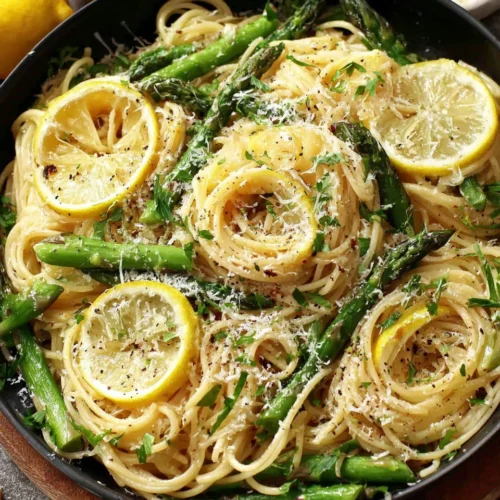 Lemon asparagus pasta dish with lemon slices and Parmesan.