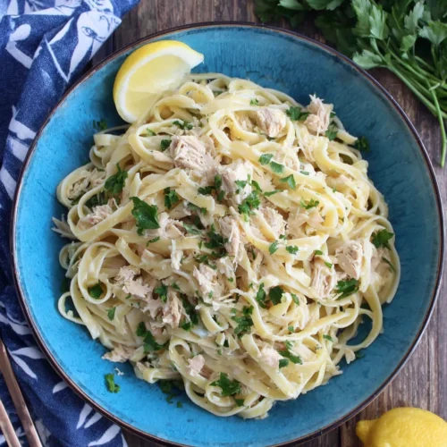 Tuna pasta dish garnished with parsley and lemon