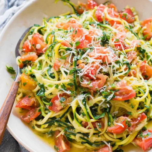 Healthy zucchini noodles with tomatoes and parmesan.