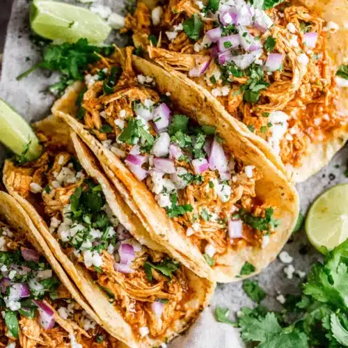 Flavorful chicken tinga tacos topped with onions and lime.