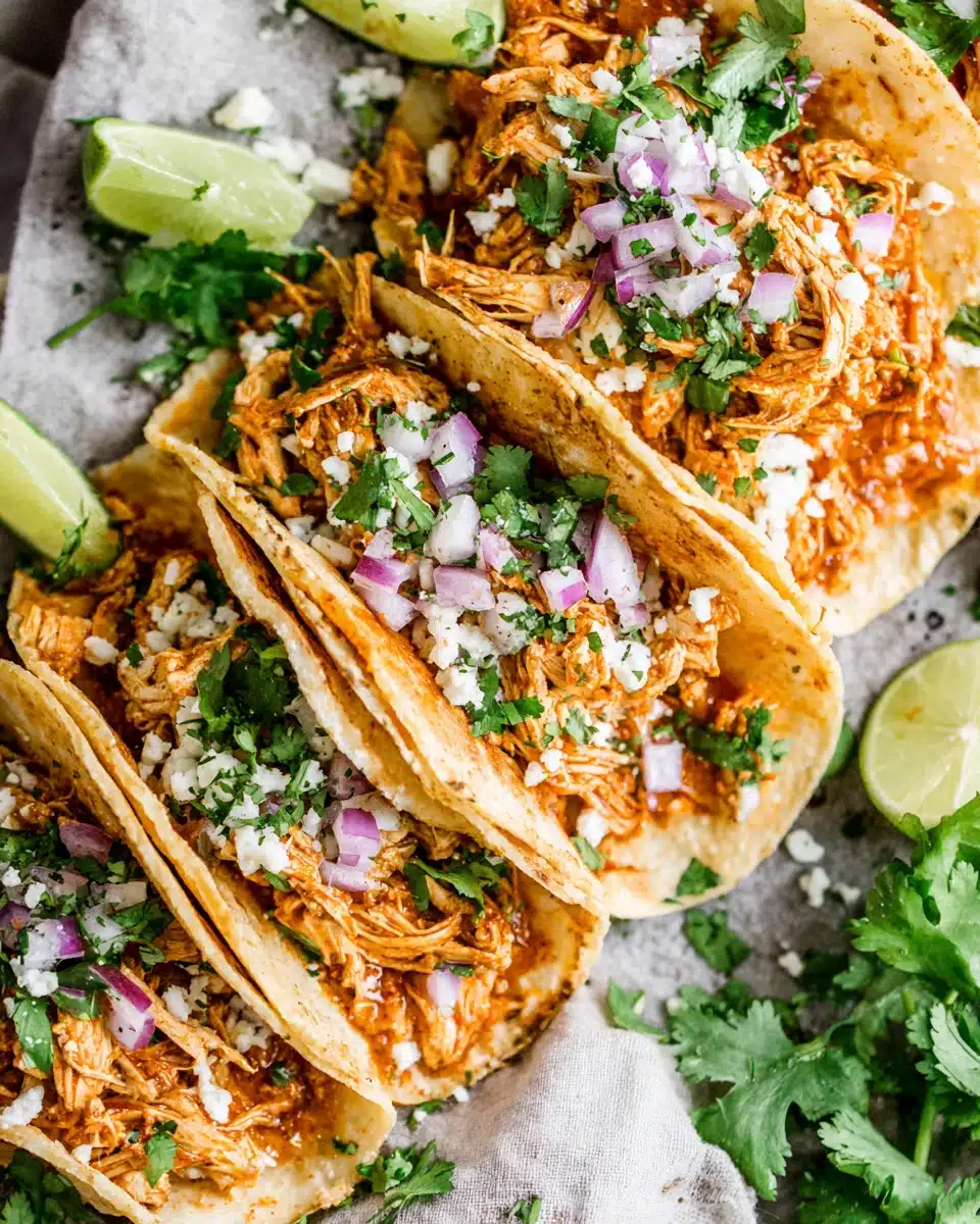 Flavorful chicken tinga tacos topped with onions and lime.