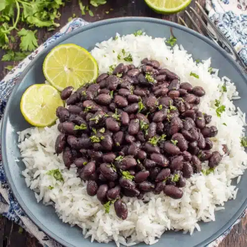 Savory Cuban style black beans over rice, garnished with parsley.