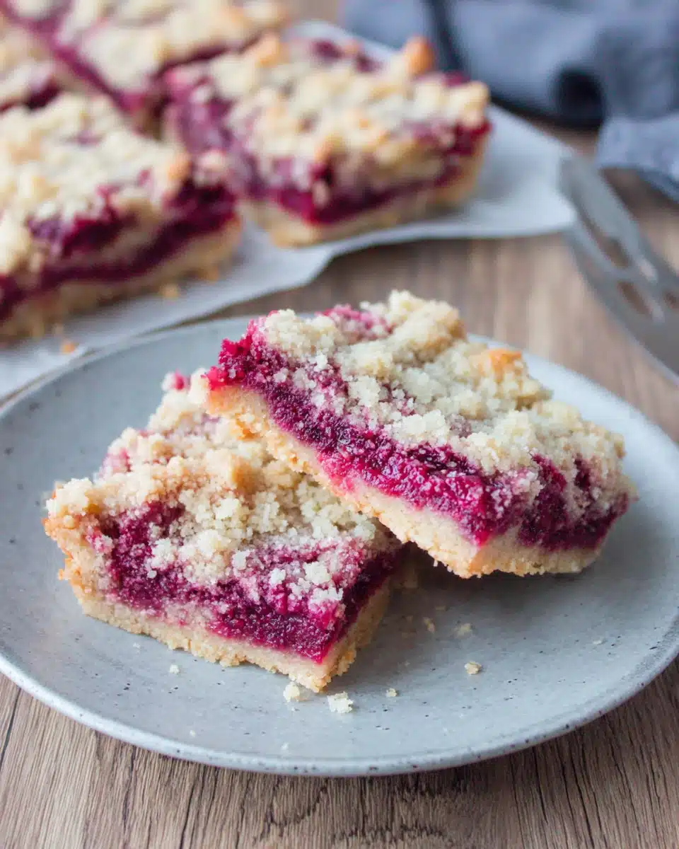 Keto raspberry crumble bars on a plate with crumbly topping and juicy filling