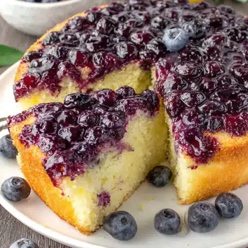 Lemon blueberry cake with juicy blueberries and golden cake layers on a white plate
