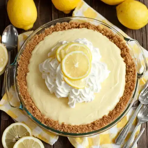 Lemon Cream Pie: A Refreshing Delight for Everyone 1 Lemon cream pie with whipped cream and lemon slices on a wooden table