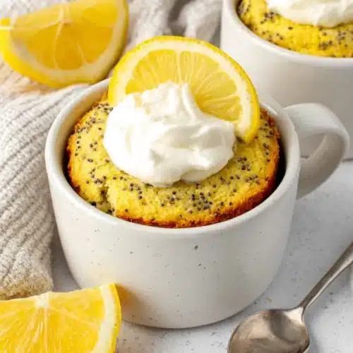 Lemon poppy seed mug cake topped with cream.