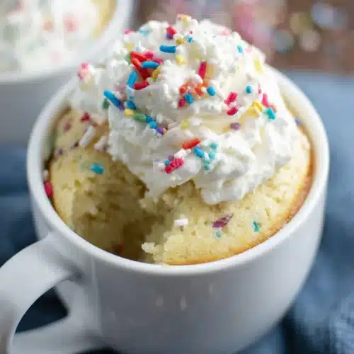 Microwave Vanilla Mug Cake: The Quickest Treat Ever! 1 Microwave vanilla mug cake with whipped cream and sprinkles.