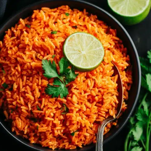 Delicious rice cooker Mexican rice garnished with lime and cilantro.