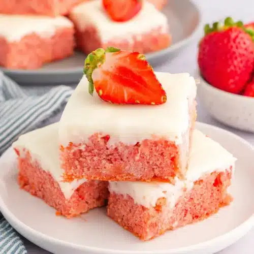 Strawberry Cake Mix Cookies: Delightfully Easy and Delicious 1 Pink strawberry cake mix bars with white frosting and fresh strawberry topping