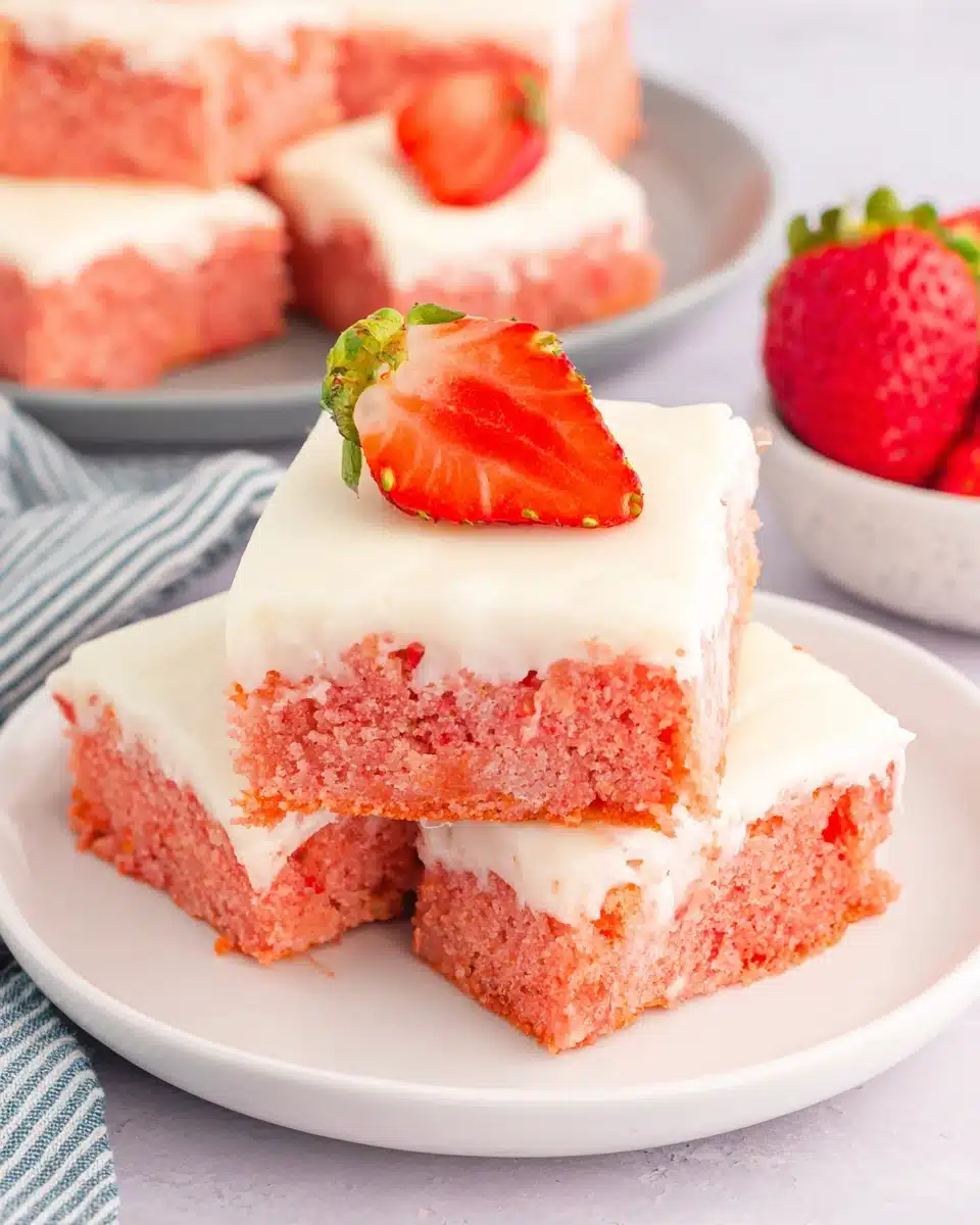 Strawberry Cake Mix Bars with Frosting Pink strawberry cake mix bars with white frosting and fresh strawberry topping