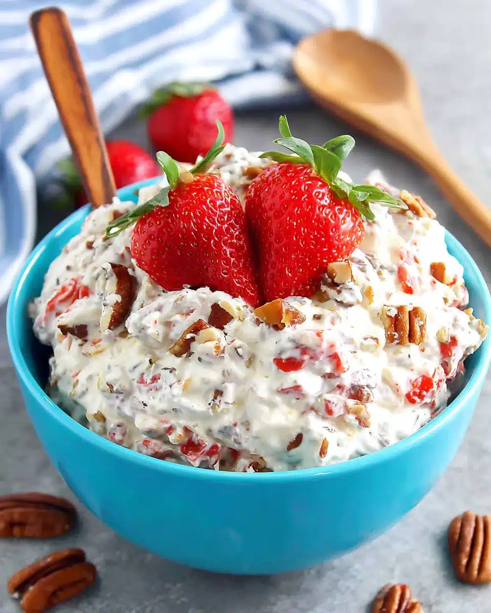 Strawberry pecan pretzel salad with fresh strawberries and creamy filling in a blue bowl