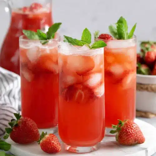 Refreshing agua de fresa in glasses with ice, strawberries, and mint garnish