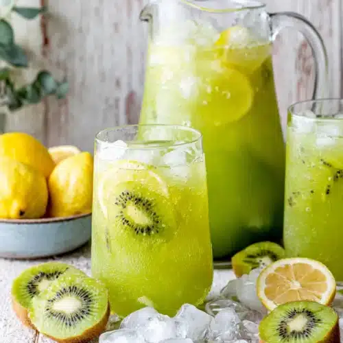 Refreshing agua de kiwi in a pitcher and glasses with lemon and ice