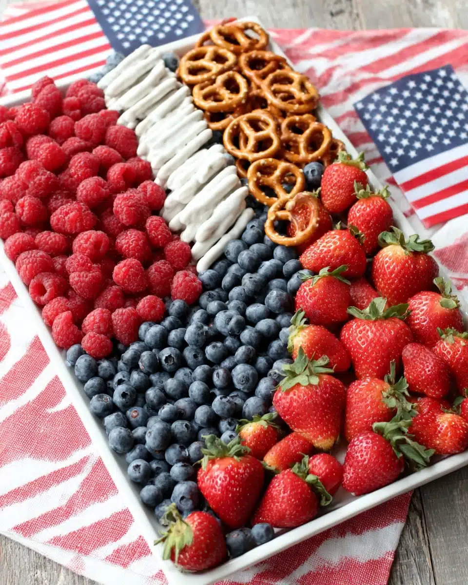 American flag fruit tray with strawberries, raspberries, blueberries, and yogurt-covered pretzels
