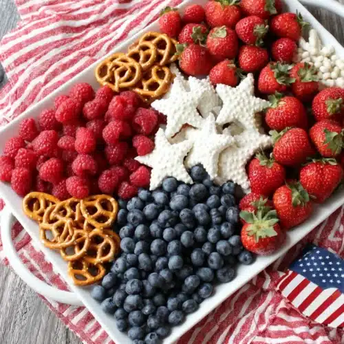 American flag fruit tray with strawberries, raspberries, blueberries, and yogurt-covered pretzels