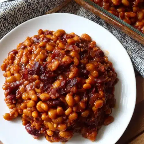 Homemade baked beans from scratch on a white plate with rich sauce