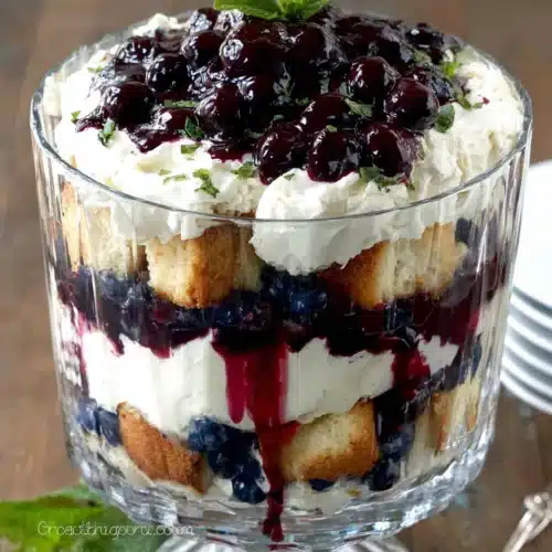 Blueberry Cheesecake Trifle: Delightful and Easy Dessert 1 Blueberry cheesecake trifle with layers of cake, cream, and blueberry filling in a glass bowl