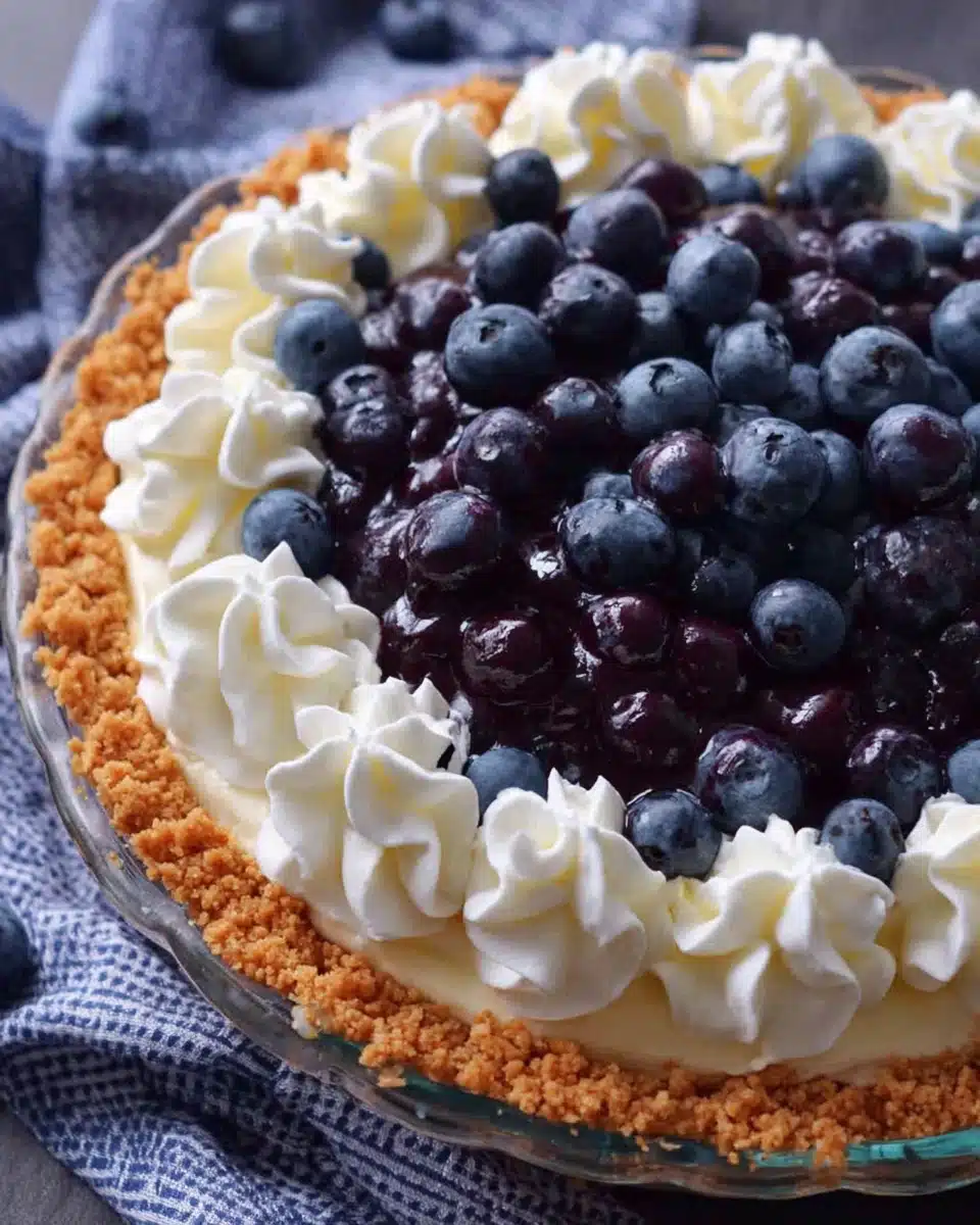 Blueberry cream cheese pie with fresh blueberries and whipped cream on graham cracker crust