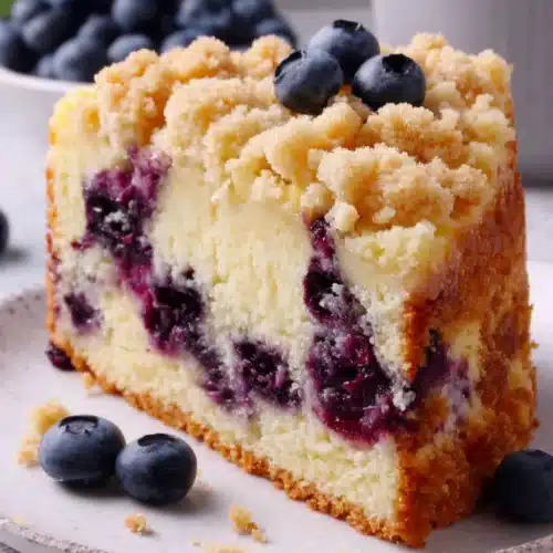 Delicious Blueberry Crumb Cake You’ll Love 1 Slice of blueberry crumb cake with crumb topping and fresh blueberries