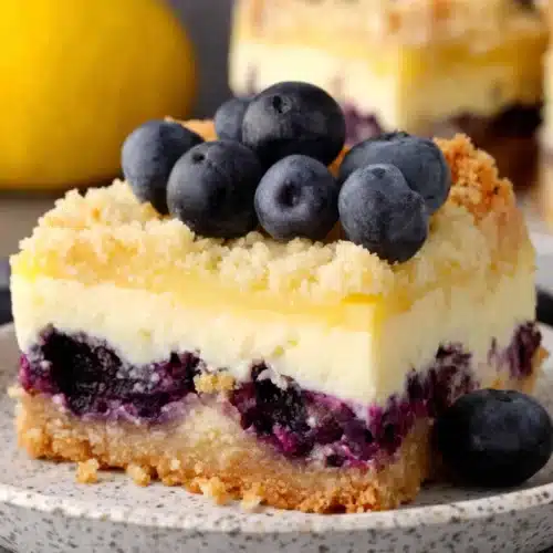 Blueberry lemon pie bars with fresh blueberries and lemon zest, served on a plate