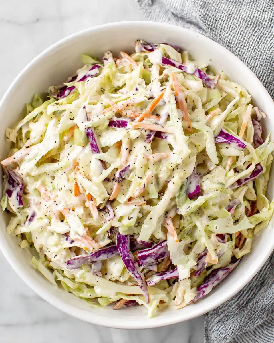 Creamy coleslaw with shredded cabbage and carrots in a white bowl