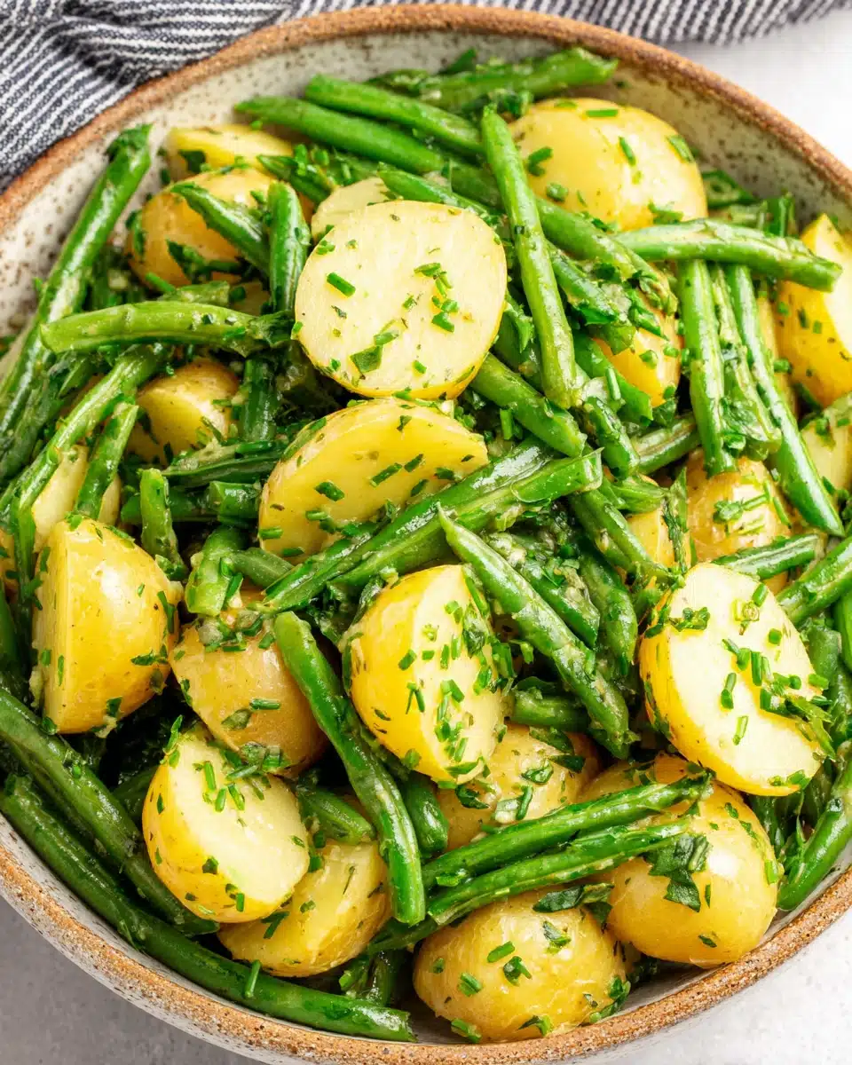 Creamy green bean potato salad with fresh herbs in a ceramic bowl