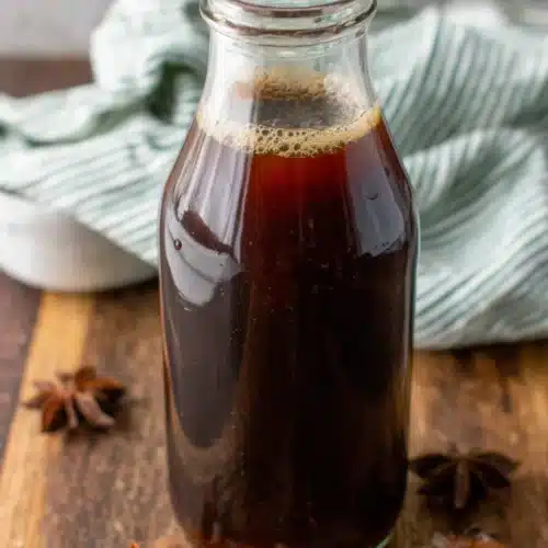 Easy chai concentrate in glass bottle with star anise on wooden table