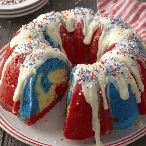 Firecracker red, white and blue cake with drizzled frosting and sprinkles