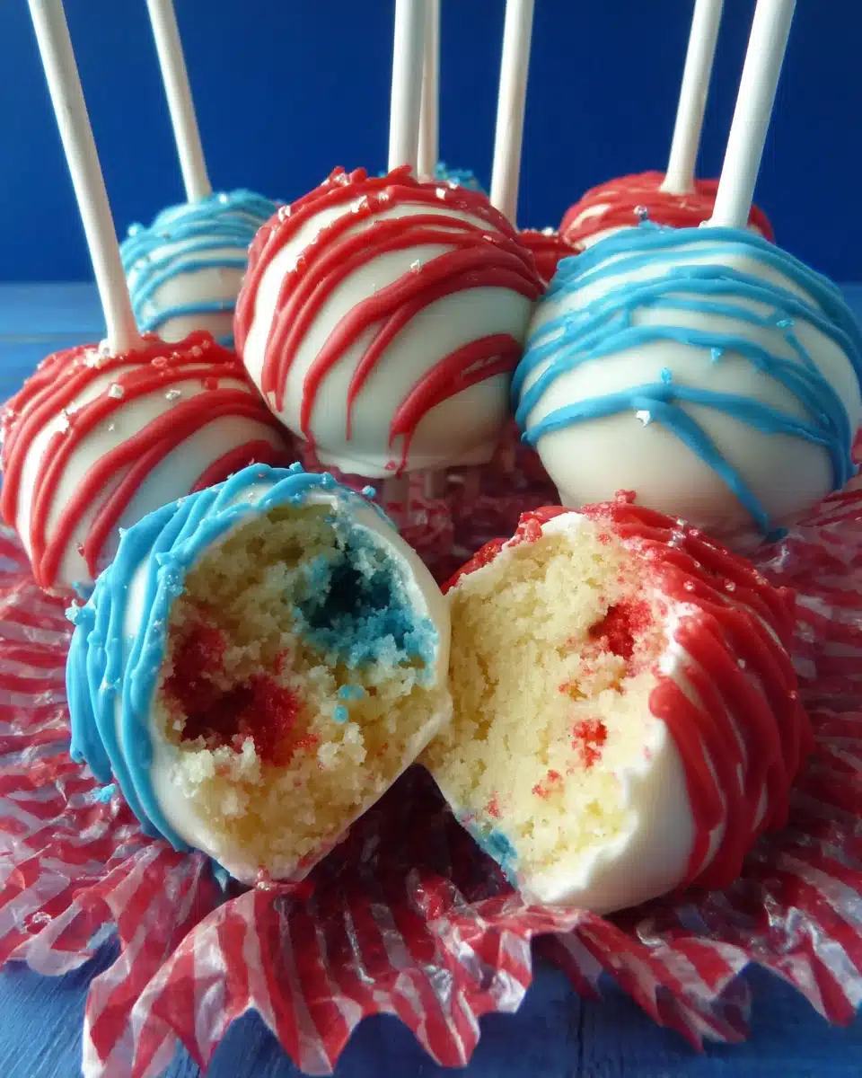 Festive Fourth of July Cake Pops with Red and Blue Centers Red, white, and blue Fourth of July cake pops with drizzled chocolate and crinkle paper
