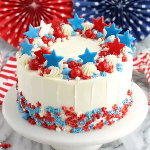 Fourth of July Layer Cake: A Festive Delight 1 Fourth of July layer cake with red, white, and blue star toppers and candies
