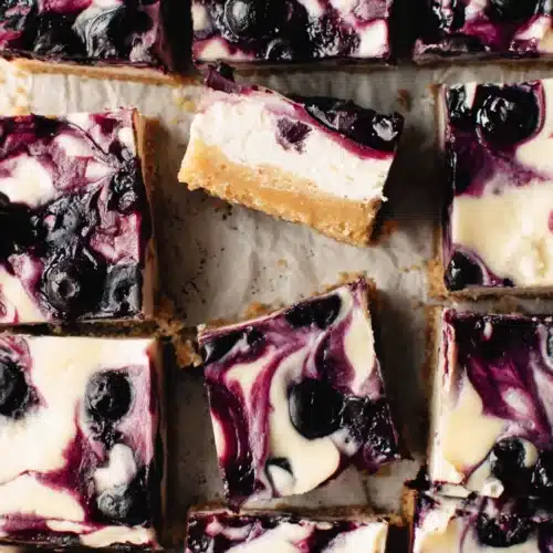 Vegan lemon blueberry cheesecake bars with creamy filling and blueberry swirl