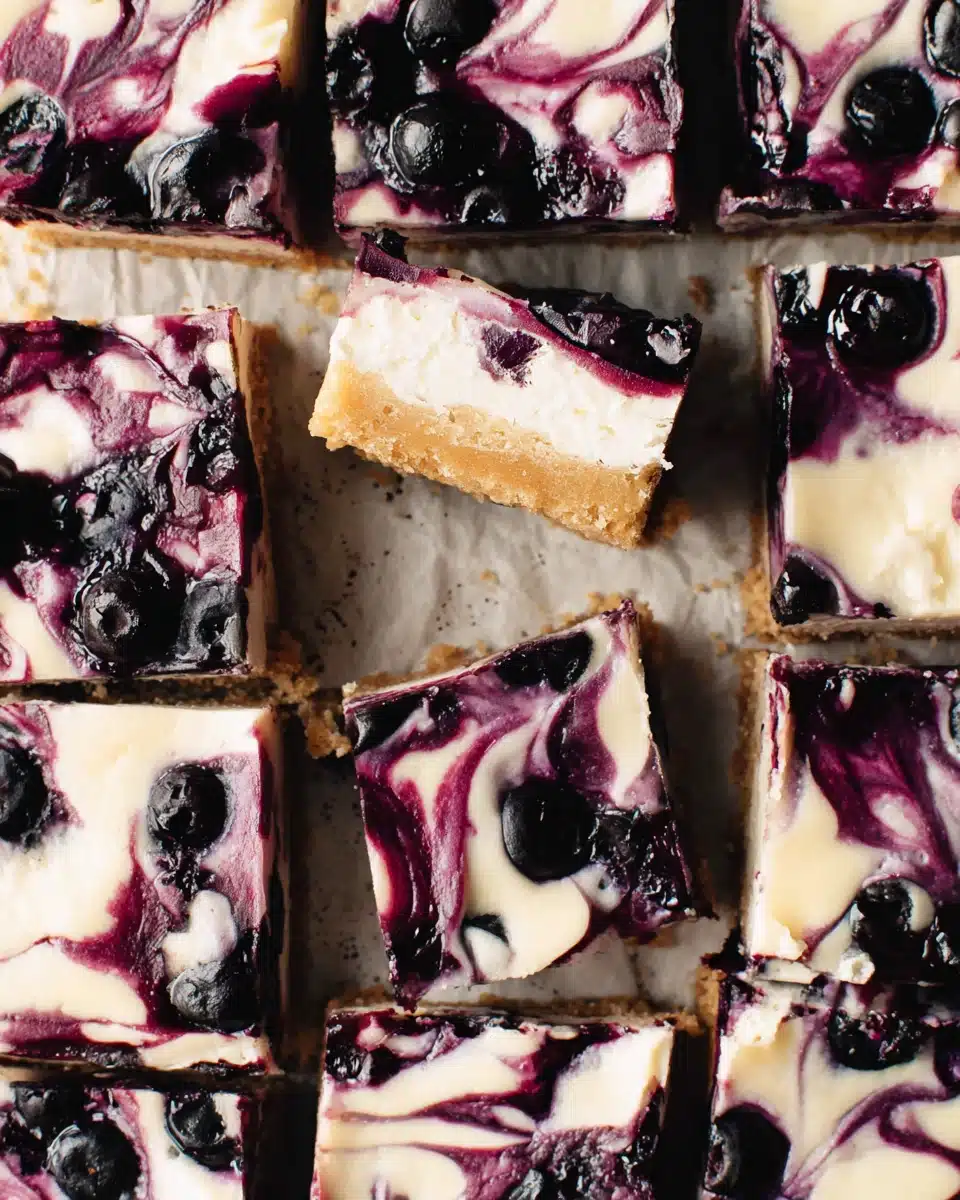 Vegan lemon blueberry cheesecake bars with creamy filling and blueberry swirl