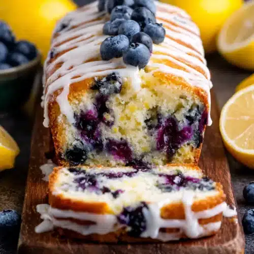 Lemon blueberry yogurt cake with white icing and fresh berries