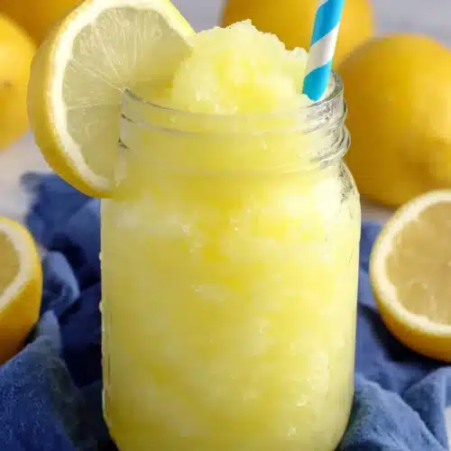 Lemonade Slushies: A Refreshingly Cool Treat 1 Lemonade slushie in a jar with lemon slice and blue straw