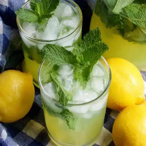 Moroccan mint lemonade with fresh lemons and mint on a checkered cloth
