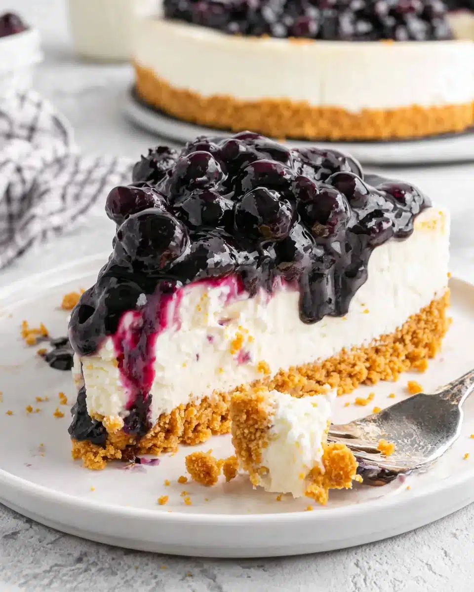 No Bake Blueberry Cheesecake Slice with Creamy Layer and Fresh Berries Slice of no bake blueberry cheesecake with graham cracker crust and blueberry topping