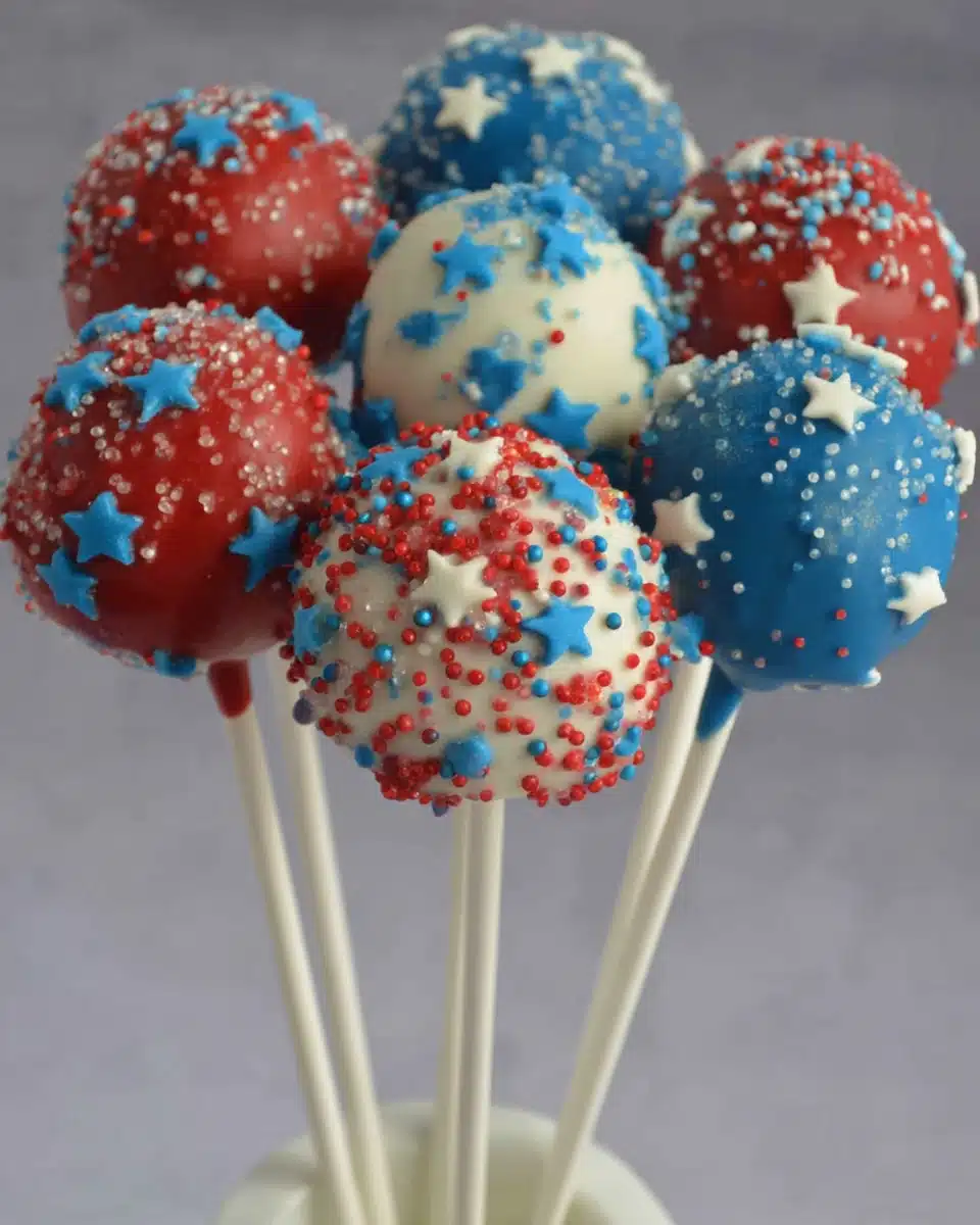 Red, white, and blue patriotic cake pops with star shapes and sprinkles for 4th of July
