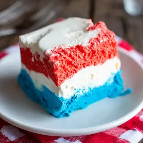 Patriotic Neapolitan ice cream slice with red, white, and blue layers on a plate