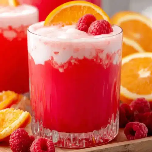 Sherbet Party Punch: A Refreshing and Fun Delight 1 Sherbet party punch in a glass with orange slice and raspberry garnish