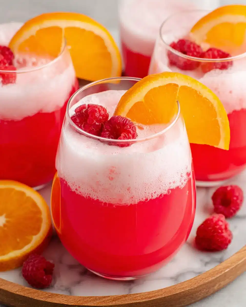Sherbet Party Punch with Fresh Fruit Garnish Sherbet party punch in glasses with raspberries and orange slices