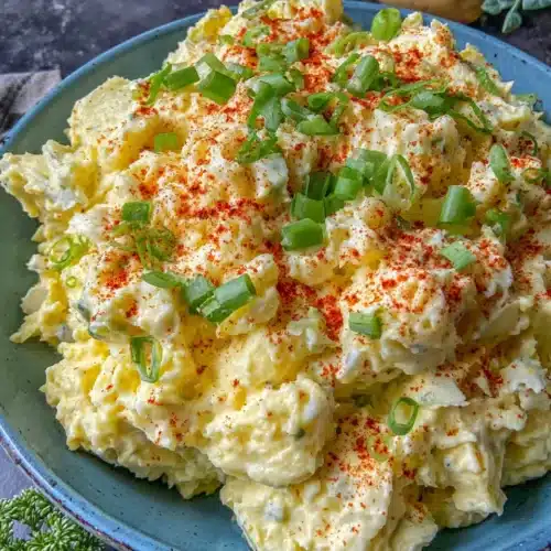Creamy southern potato salad with hard-boiled eggs, green onions, and paprika