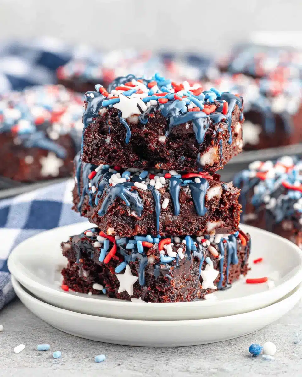 Star spangled brownies with blue drizzle and red, white, blue sprinkles on white plates