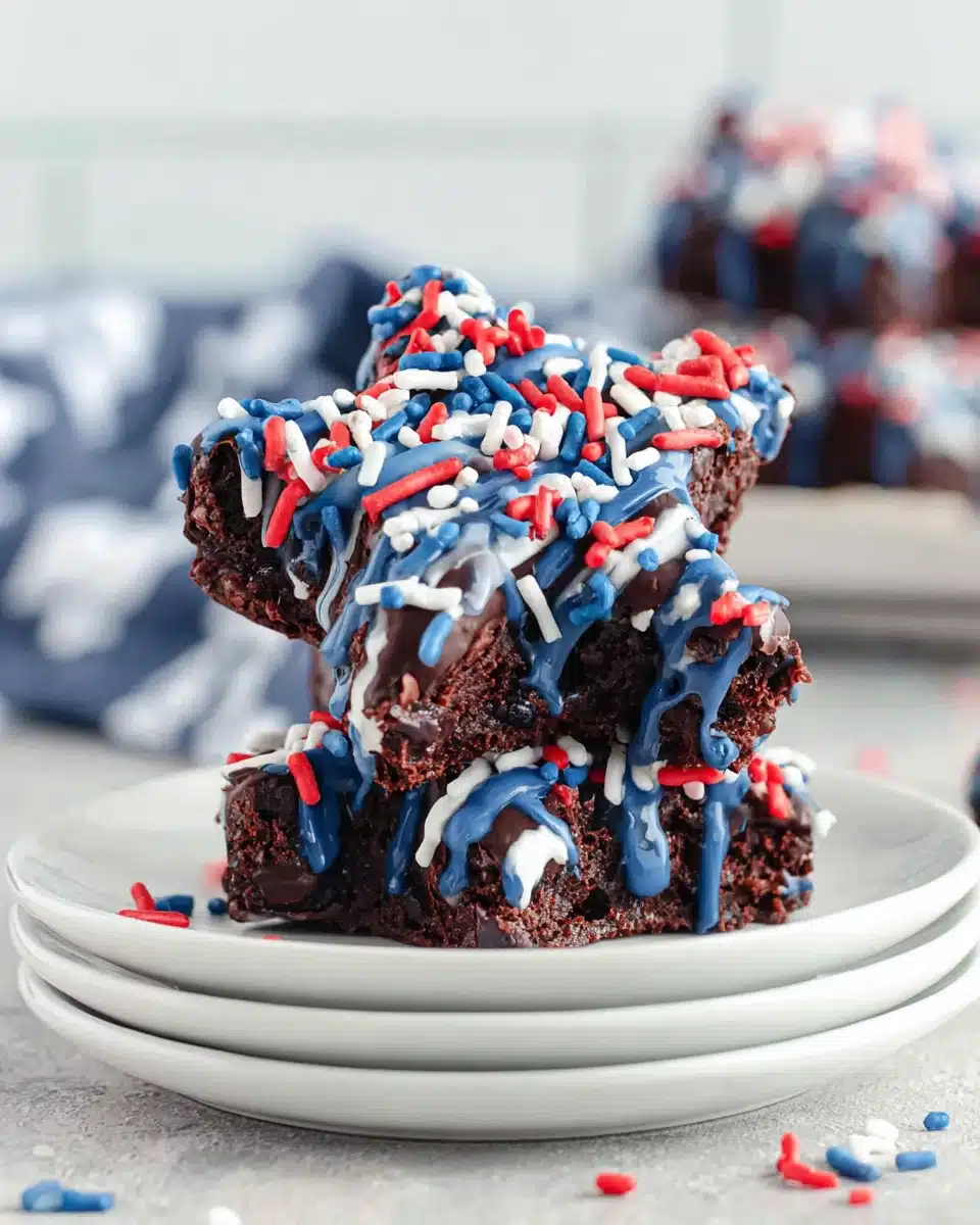 Star spangled brownies with blue drizzle and red, white, blue sprinkles on white plates