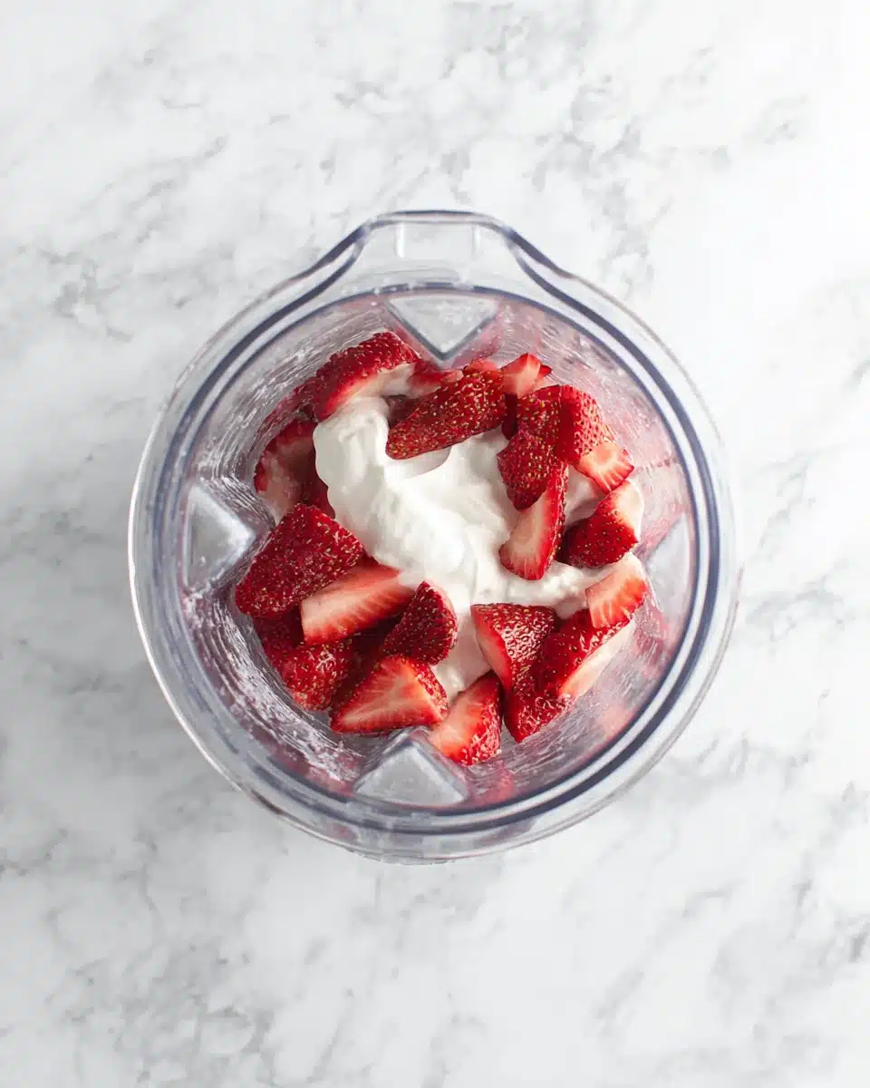 Strawberry smoothie recipe with yogurt ingredients in a blender
