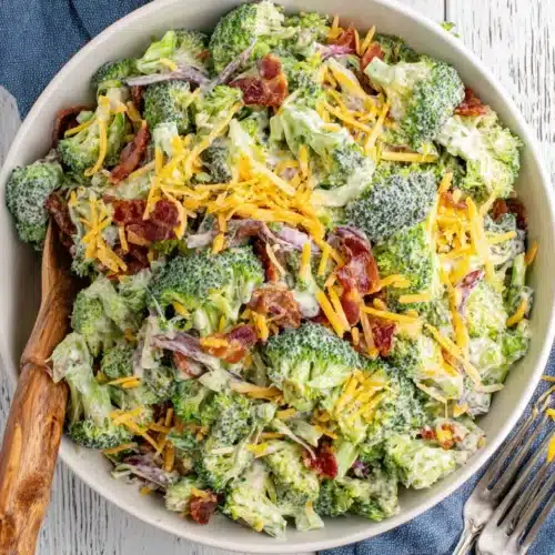 Tasty Ruby Tuesday Broccoli Salad: A Flavorful Delight 1 Tasty Ruby Tuesday broccoli salad with broccoli, bacon, cheese, and creamy dressing in a white bowl