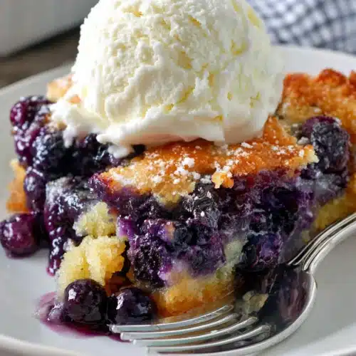 Texas-Style Blueberry Cobbler: A Deliciously Simple Delight 1 Texas-style blueberry cobbler with vanilla ice cream on a white plate