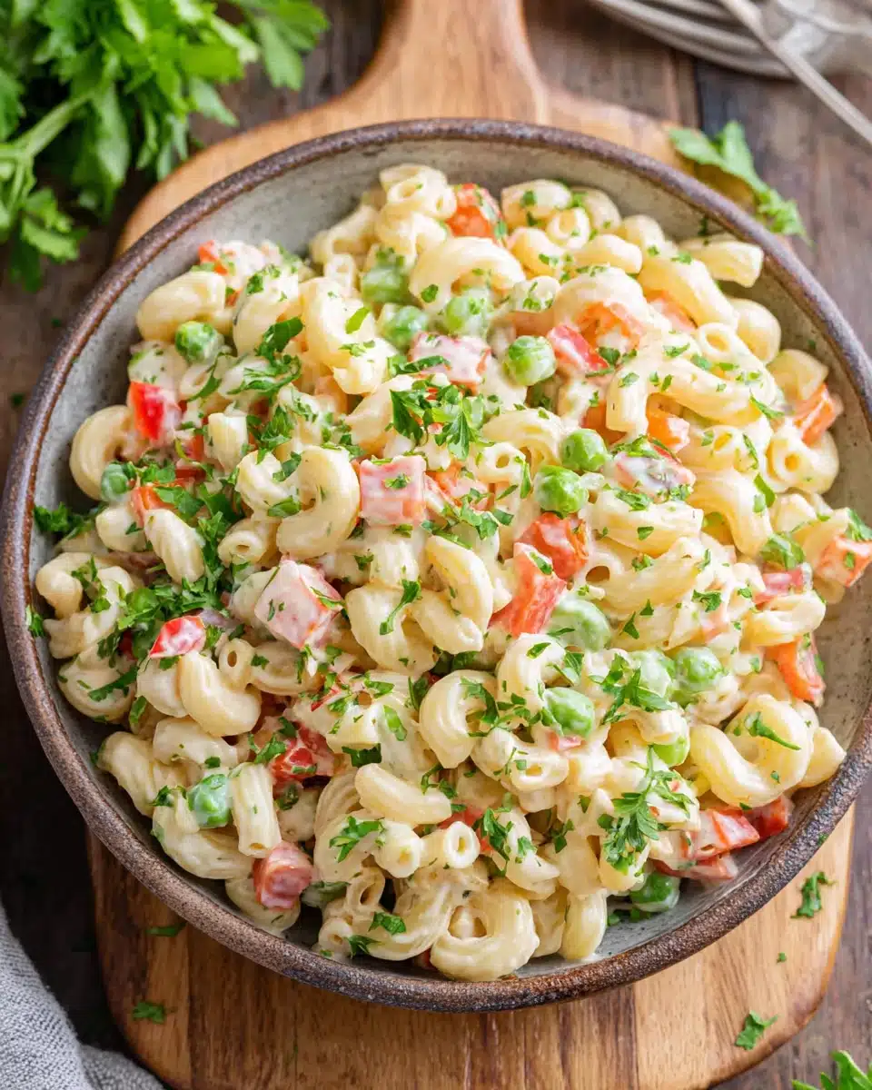 Creamy vegan macaroni salad with fresh vegetables and herbs in a bowl