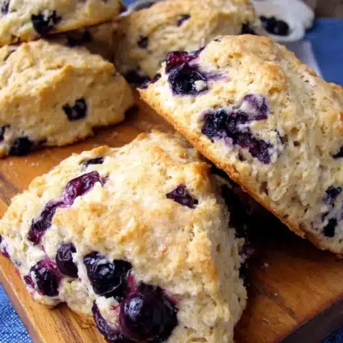 Easy Whole Wheat Blueberry Scones That Will Delight 1 Golden whole wheat blueberry scones with juicy berries on a wooden board