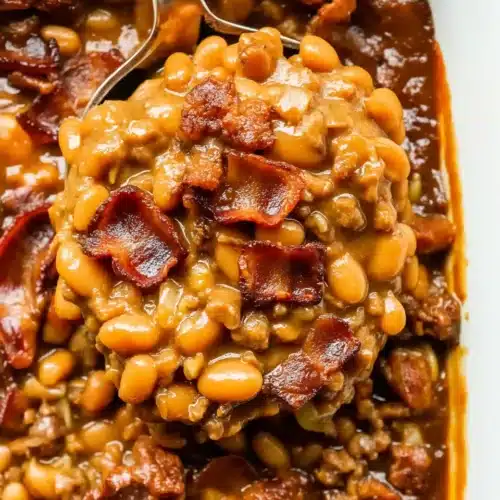 Savory BBQ baked beans with bacon and sauce, served with a spoon