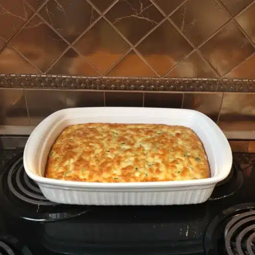 Betty Crocker zucchini pie in a white baking dish on a stovetop